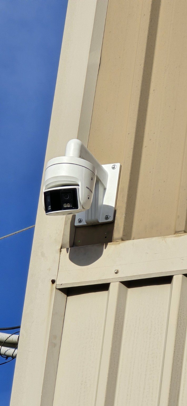 Commercial security camera installed high on an exterior building wall