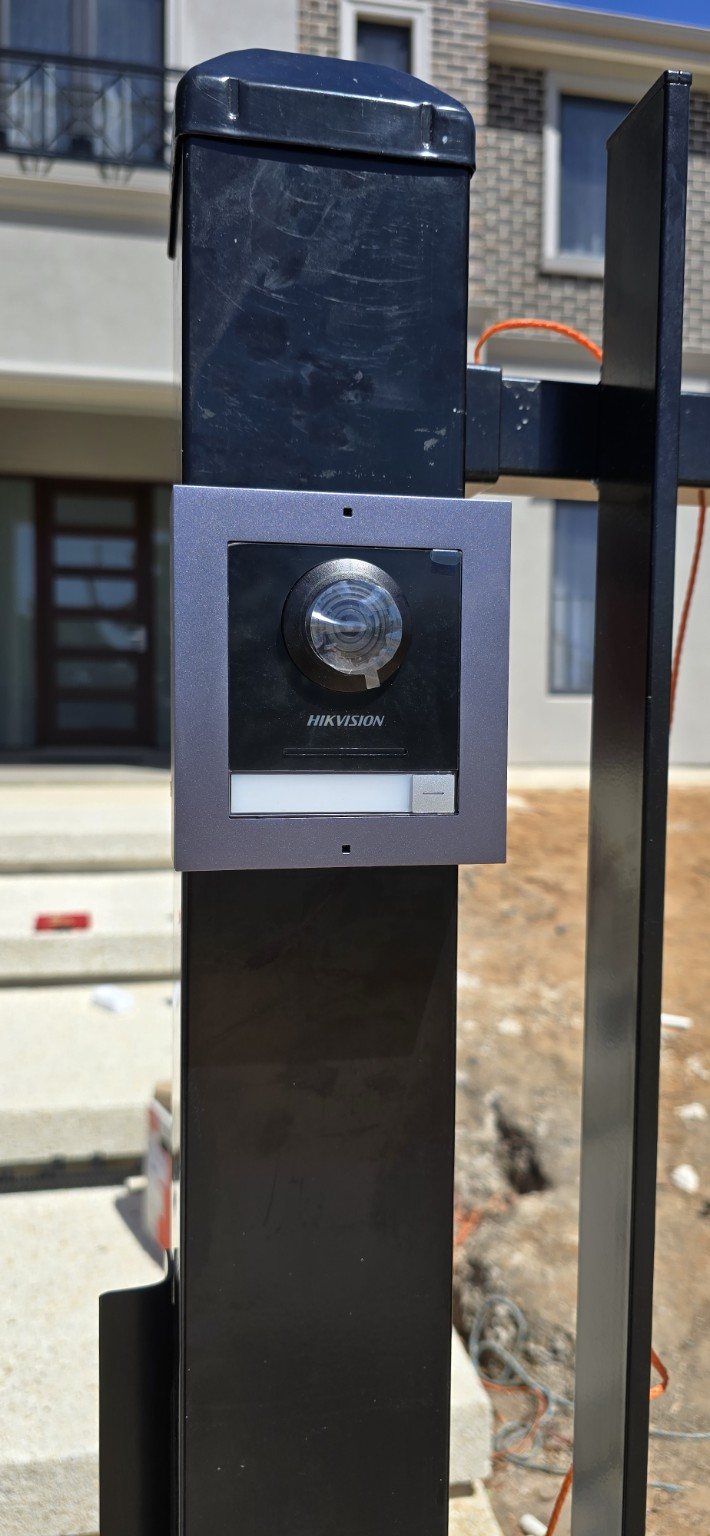 Video intercom station installed on a modern driveway gate